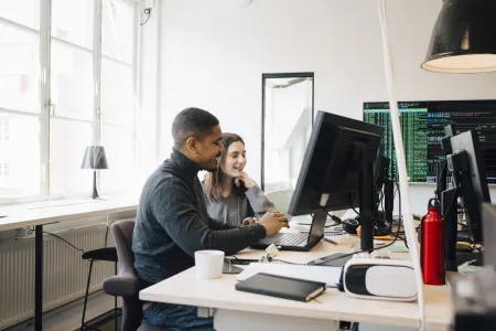 Man and woman looking at computer screen in office