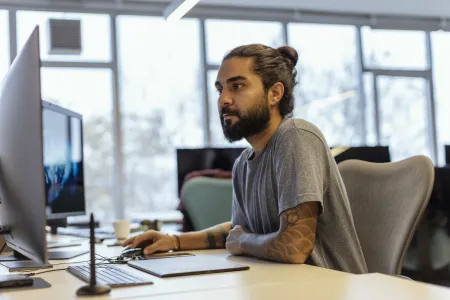 Man in office sitting behind computer screen