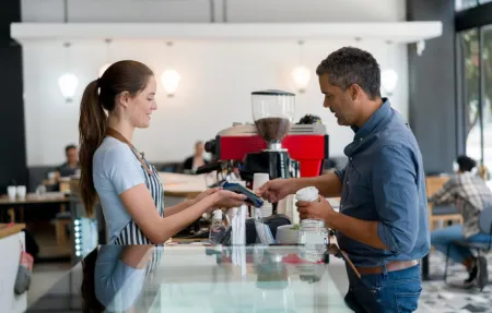 Man at coffee shop paying with contactless payment