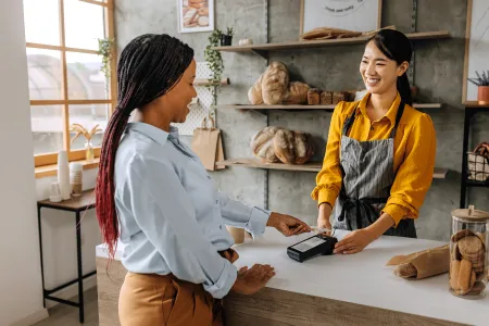 Woman using contactless payment at bakery