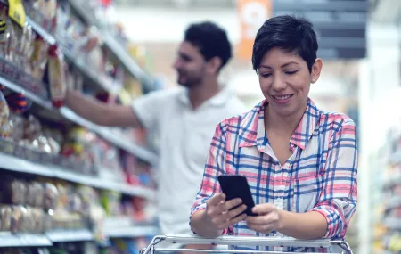 Retail_Women checking her phone in supermarket.png