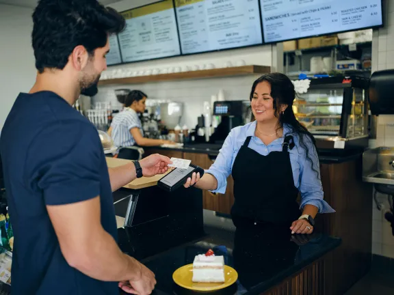 Man at coffee shop paying with contactless payment